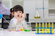 Asian woman teacher and little children girl making science experiments tests in chemical laboratory study room. Education research and development concept learning for kids.