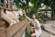 A woman petting a sheep at an animal zoo in thailand, thailand, thailand, thailand, thailand, thailand, thailand, thailand