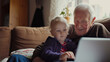 Grandparents and grandchild using laptop at home