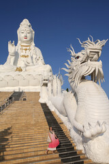 Wall Mural - Tourist woman, fashion girl and Wat Huay Pla Kang in Chiang Rai city, Thailand. Religious traditional national Thai architecture. Landmark, architectural monument. Buddhist temple, sight