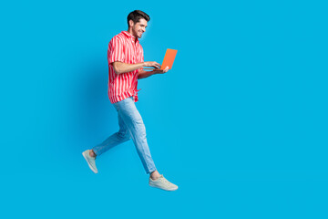 Aufkleber - Full size photo of smart man dressed striped shirt denim pants hurry run empty space texting on laptop isolated on blue color background