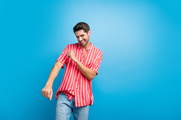 Poster - Portrait of handsome pleasant guy with stubble wear stylish shirt dancing having fun at summer party isolated on blue color background