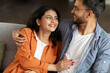 © Home-stock - Happy relationship. Loving indian spouses embracing and smiling to each other, relaxing on couch, enjoying cozy cuddle, closeup