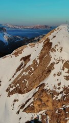 Wall Mural - Aerial around view of amazing rocky mountains in snow at sunrise, Dolomites, Italy. Vertical video