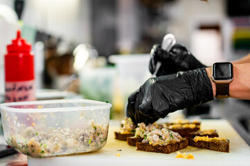 Wall Mural - Professional chef cooking forshmak of herring with black bread in restaurant kitchen