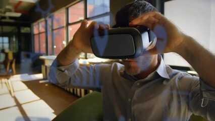 Poster - Animation of communication media icons over caucasian casual businessman using vr headset