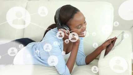 Poster - Animation of network of connections with icons over african american woman using tablet