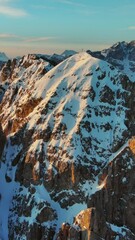 Wall Mural - Aerial view of amazing rocky mountains in snow at sunrise, Dolomites, Italy. Vertical video