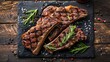 Steaks T-bone. Sliced beef grilled T-bone or porterhouse meat steak with spices rosemary and pepper on black marble board on old wooden background.
