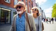 Elderly couple joyfully strolling through city streets during spring vacation.