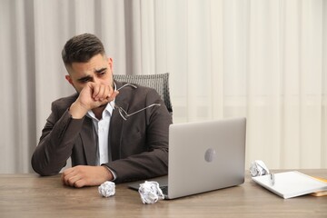 Wall Mural - Sad businessman sitting at table in office