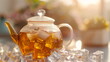 The elegant simplicity of a glass teapot filled with golden iced tea, a cool indulgence on a sunlit wooden surface.