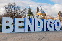 A Large Sign Made Up Of Tall White Letters Sitting On A Paved Section In A City Garden