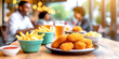 Chicken Nuggets mit Pommes im Vordergrund, im Hintergrund Aussengastronomie, Restaurant mit Gästen 