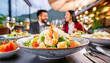 Salat mit Garnelen, im Hintergrund ein Restaurant mit Menschen 