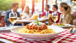 Spaghetti Bolognese, im Hintergrund ein Restaurant mit fröhlichen Menschen 