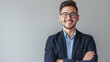 © MP Studio - a smiling person with glasses and facial hair, wearing a suit jacket over a collared shirt, standing with arms crossed against a neutral background