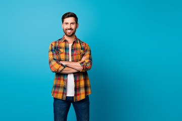 Canvas Print - Photo of attractive young man folded hands confident entrepreneur dressed stylish checkered clothes isolated on blue color background