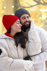 Wall Mural - Portrait of lovely couple outdoors against blurred lights outdoors