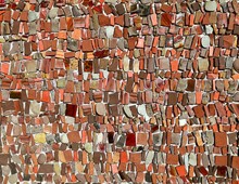 Mosaic Made Of Red Shades Pebbles And Fragments Of Brick  On Concrete Backdrop. Detail. Background And Texture.