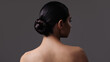 Portrait of a brunette girl with a bun hairstyle. Back view.