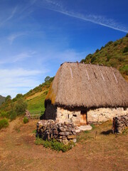 Poster - Old wooden and straw building in the Celtic style in the mountains, to store the animals of the herd