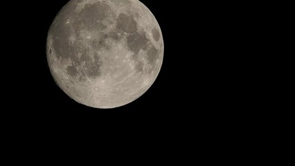 Wall Mural - Full moon moves fast at night sky. Sharp footage of full moon with telephoto lens close-up. Moon shot from ground. Moon witchcraft magic ritual concept.