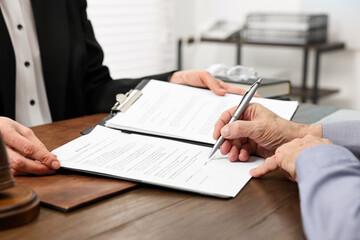 Poster - Senior man signing document in lawyer's office, closeup