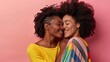 Two women share a joyful embrace, their human faces beaming with happiness as they stand in front of a wall, their jheri curls and black hair framing their contented smiles and stylish clothing