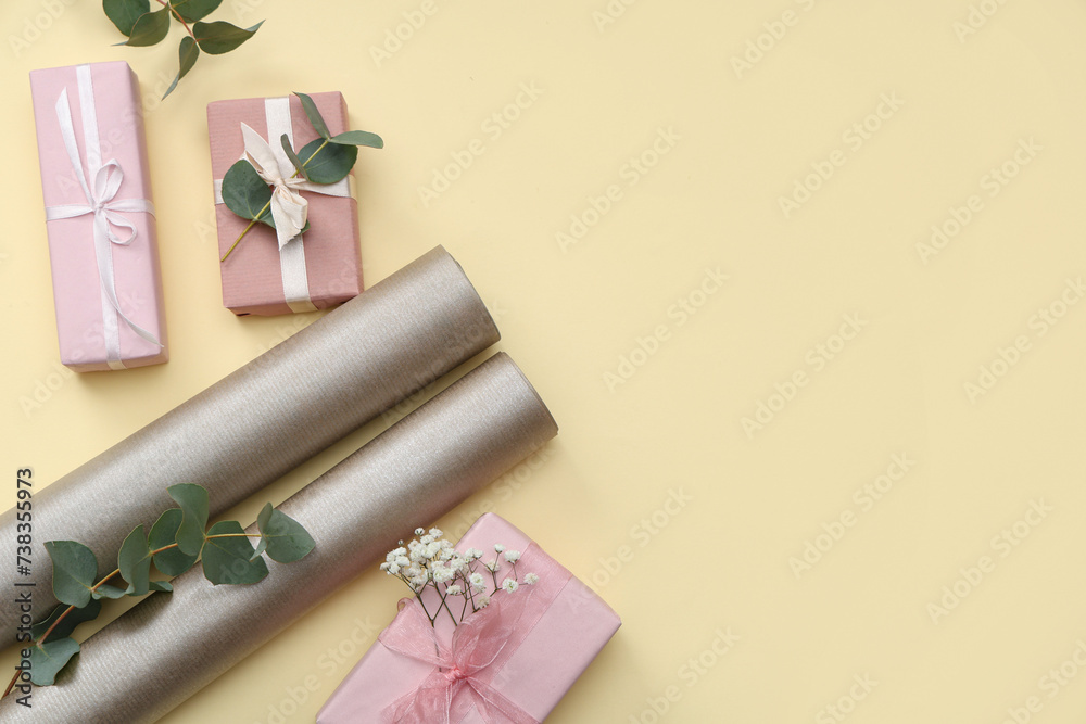 Gift boxes with wrapping paper and gypsophila flowers on yellow background. International Women's Day