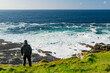 © MNStudio - Tourist admiring scenic beauty of Malin Head, Ireland's northernmost point, Wild Atlantic Way, spectacular coastal route. Wonders of nature. Co. Donegal