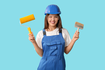 Sticker - Young female painter with brush and roller on blue background