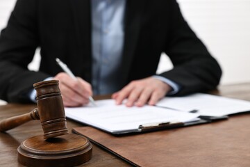 Wall Mural - Man signing document in lawyer's office, focus on gavel