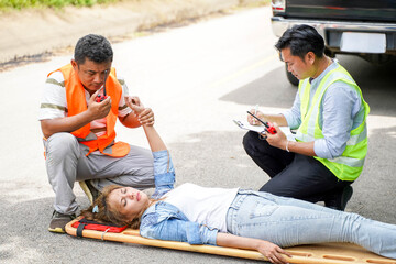 Closeup rescue workers using radio communication helping woman driver from car accident on road.