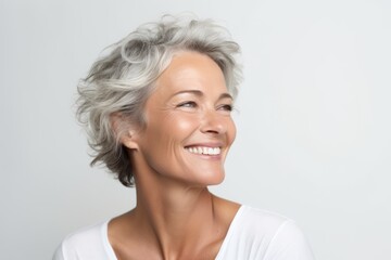 Portrait of a happy senior woman smiling at the camera over grey background