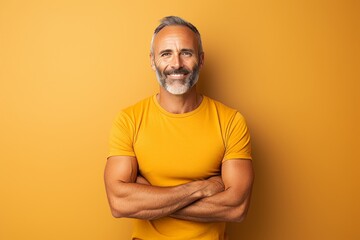 Canvas Print - Handsome mature man in yellow t-shirt on yellow background