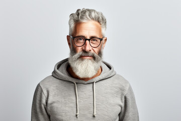 Confident mature man with beard wearing casual hoodie on grey backdrop. Modern casual style.