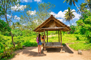 Canvas Print - A family relaxing along a roof protected relax zone in Bali, Indonesia