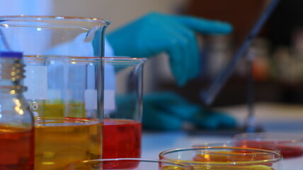 scientists are doing research in a science lab. a medical chemist in a white coat, gloves and goggle