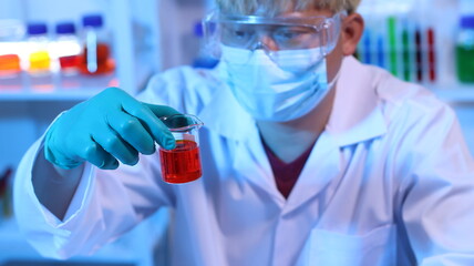 scientists are doing research in a science lab. a medical chemist in a white coat, gloves and goggle