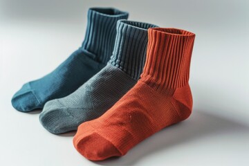 Aufkleber - Three pairs of socks sitting next to each other. Can be used to showcase different styles, colors, or patterns of socks.