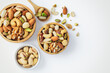 Mixed nuts in wooden bowl on white background