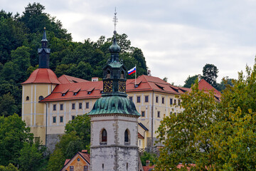 Wall Mural - Old town with historic houses, church tower and castle on a hill at City of Skofja Loka on a cloudy summer day. Photo taken August 9th, 2023, Škofja Loka, Slovenia.