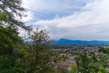 Wall Mural - Aerial view of City of Ljubljana seen from Sance castle hill with mountain panorama in the background on a cloudy summer day. Photo taken August 9th, 2023, Ljubljana, Slovenia.