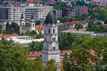 Wall Mural - Aerial view of Slovenian City of Ljubljana with church tower seen from viewpoint of castle hill on a cloudy summer day. Photo taken August 9th, 2023, Ljubljana, Slovenia.