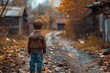 A curious young boy stands amidst the vibrant autumn foliage, his tiny frame a stark contrast against the towering tree and rugged dirt road