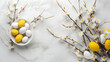 Crisp details capture the elegance of a flat lay Easter arrangement with a graceful willow branch and colorful eggs arranged artfully on white. 