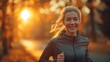 A smiling woman is jogging in a sunlit forest, exuding health and vitality during golden hour