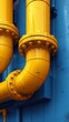 The image shows bold yellow industrial pipes against a vibrant blue wall, creating a striking contrast