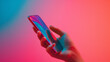 © Gimbalock - hand holding smart phone on colorful background